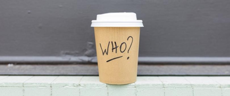 a coffee cup with "who?" written on it to represent an about us page story.