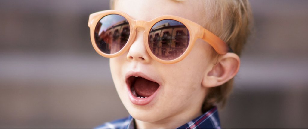 Excited kid wearing sunglasses looking cool
